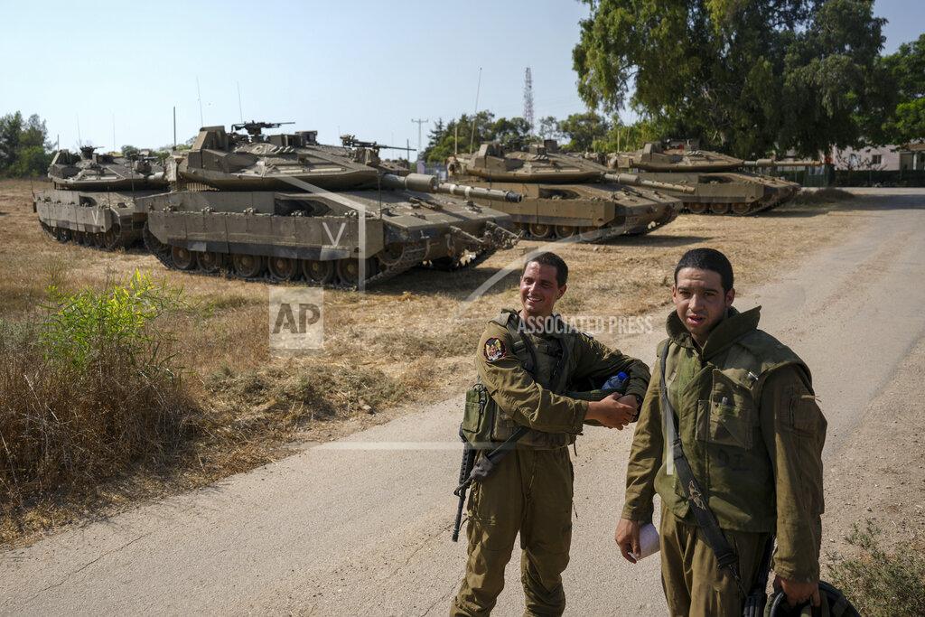 Ariel Schalit Israeli soldiers near their tanks in an area near the border with Gaza Strip, Friday, Aug. 5, 2022. Israel has closed roads near Gaza and sent in troop reinforcements as it braces for a possible revenge attack, following the arrest of a senior Palestinian militant in the occupied West Bank earlier this week. (AP Photo/Ariel Schalit)