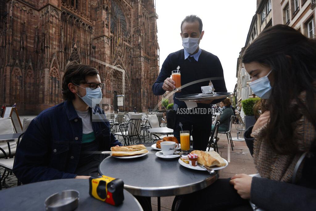 Jean-Francois Badias People enjoy a breakfast at a café terrace Wednesday, May, 19, 2021 outside the cathedral in Strasbourg, eastern France. Café and restaurant terraces are reopening Wednesday after a shutdown of more than six months deprived people of what feels like the essence of life — sipping coffee and wine with friends outdoors — to save lives during the coronavirus pandemic. (AP Photo/Jean-Francois Badias)