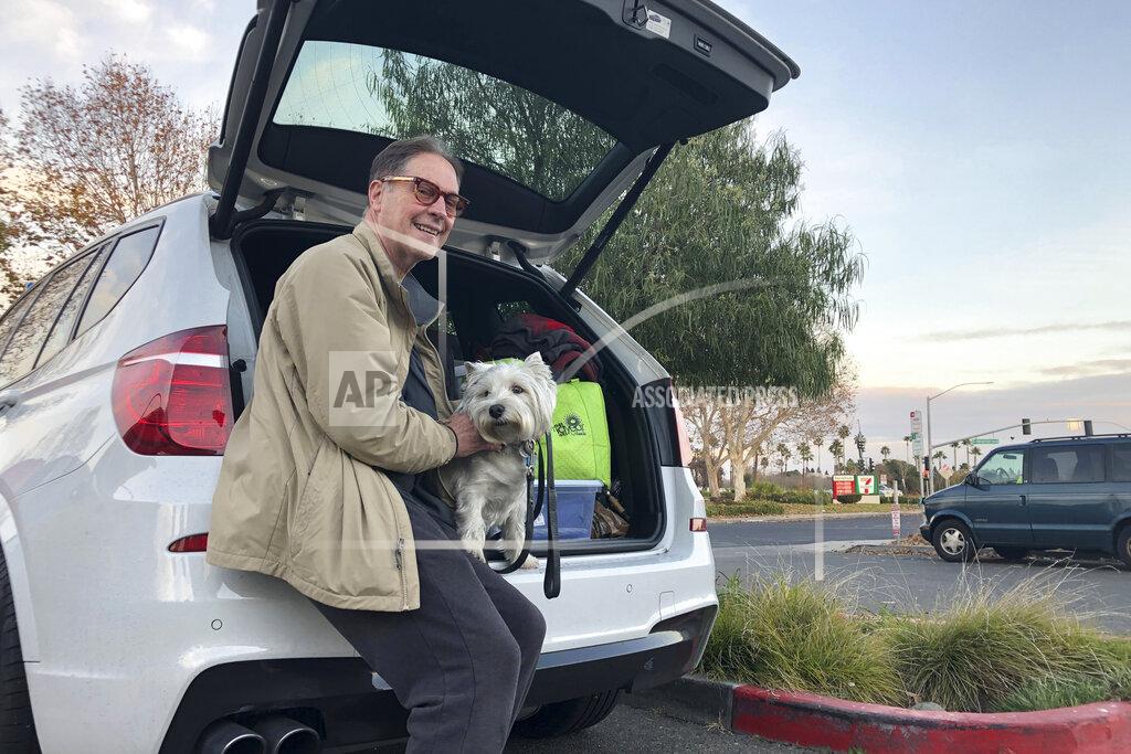 Adam Beam Matt Frinzi, 68, poses with his dog, Whitey, and his car filled with his belongings, in West Sacramento, California, on Tuesday, Dec. 15, 2020. Prinzi has lived in California for 25 years. But Tuesday he officially moved to Reno, Nevada. He said his quality of life has deteriorated so much in California that he wanted to leave. California saw its slowest growth rate on record for the nation's most populous state, adding just 21,200 people during the year that ended in July, state officials said Wednesday, Dec. 16, 2020. (AP Photo/Adam Beam)