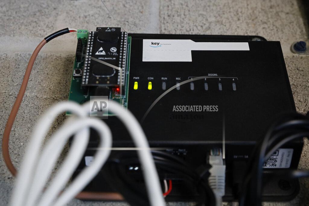 Shafkat Anowar An Amazon device that gives delivery personnel access to a building's front doors to deliver packages, is shown Monday, March 29, 2021, in Chicago. The online shopping giant is making a push to install a device on buzzer systems in apartment buildings throughout the country that allows its delivery drivers to whip out a phone, tap a button and unlock a building's front doors whenever they need to leave packages in the lobby instead of the street. (AP Photo/Shafkat Anowar)