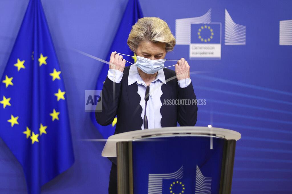 FILE - In this Nov. 16, 2020, file photo, European Commission President Ursula von der Leyen removes her face mask as she arrives to give a statement at the EU headquarters in Brussels. The European Union still hasn't completely sorted out its messy post-divorce relationship with Britain — but it has already been plunged into another major crisis. This time the 27-member union is being tested as Poland and Hungary block passage of its budget for the next seven years and an ambitious package aimed at rescuing economies ravaged by the coronavirus pandemic. (Kenzo Tribouillard, Pool Photo via AP, File)