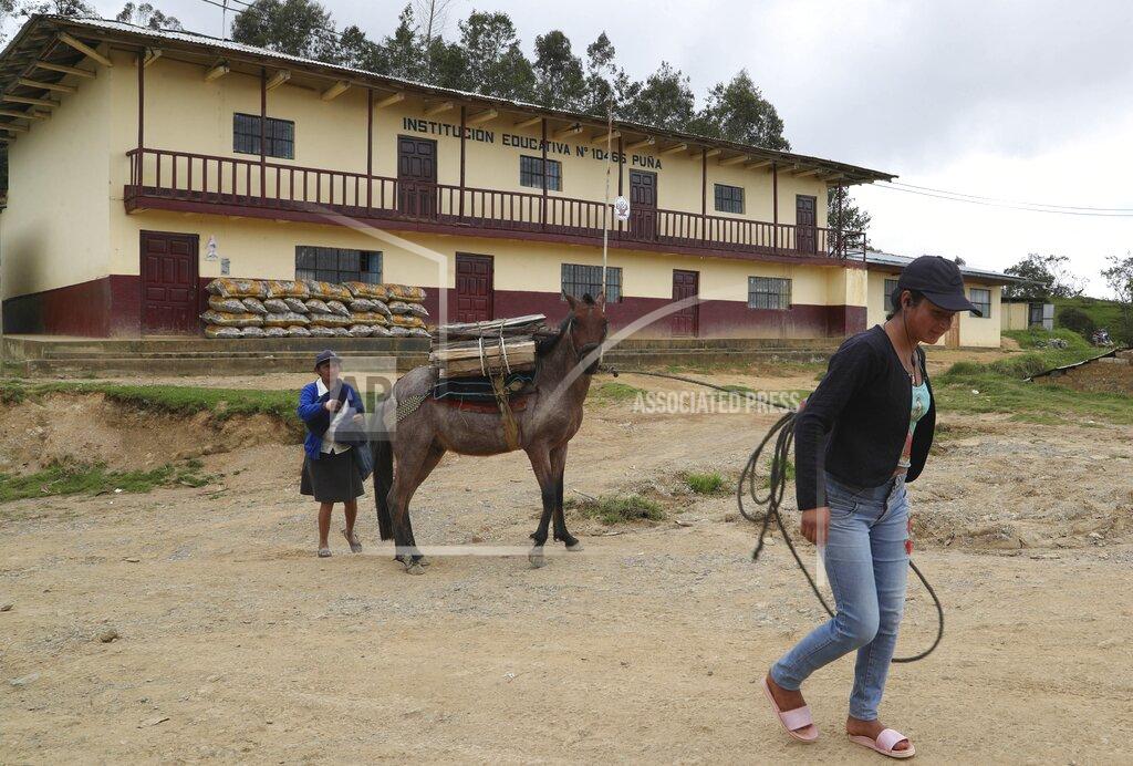 Martin Mejia A woman pulls her horse carrying wood past the school where Free Peru party presidential candidate Pedro Castillo works as a teacher in Puna, Peru, Friday, April 16, 2021. Castillo, who has proposed rewriting Peru's constitution and deporting all immigrants living in the country illegally who commit crimes, will face rival candidate Keiko Fujimori in the June 6 presidential run-off election. (AP Photo/Martin Mejia)