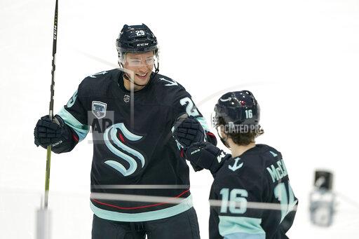 Seattle Kraken defenseman Vince Dunn, left, greets center Jared McCann after McCann scored a goal against the Carolina Hurricanes with an assist from Dunn during the second period of an NHL hockey game Wednesday, Nov. 24, 2021, in Seattle. (AP Photo/Ted S. Warren)