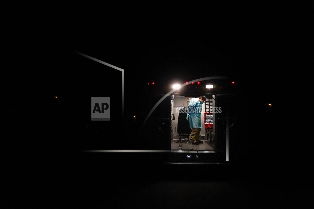 Jae C. Hong Paramedic Trenton Amaro puts on his PPE in an ambulance before entering a home to treat a COVID-19 patient in Placentia, Calif., Friday, Jan. 8, 2021. Unlike doctors and nurses, first responders must go inside homes. They walk into hot zones where everyone in a household is sick, where the virus is in the air. They lift immobile patients onto gurneys, their masked faces just inches apart. (AP Photo/Jae C. Hong)