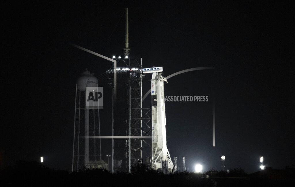 Joel Kowsky A SpaceX rocket with the company's Dragon capsule is illuminated by spotlights on the launch pad, early Friday, April 23, 2021, at NASA's Kennedy Space Center in Cape Canaveral, Fla. SpaceX aimed to launch its third crew a little before sunrise Friday, this time using a recycled capsule and rocket. The four astronauts, representing the U.S., Japan and France, were supposed to fly to the International Space Station on Thursday. But liftoff was delayed because of poor weather offshore. (Joel Kowsky/NASA via AP)