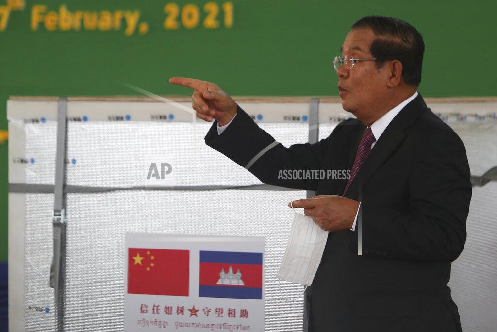 Heng Sinith Cambodian Prime Minister Hun Sen gestures during a handover ceremony at Phnom Penh International Airport, in Phnom Penh, Cambodia, Sunday, Feb. 7, 2021. Cambodia on Sunday received its first shipment of COVID-19 vaccine, a donation of 600,000 doses from China, the country's biggest ally. Beijing has been making such donations to several Southeast Asian and African nations in what has been dubbed "vaccine diplomacy," aimed especially at poorer countries like Cambodia. (AP Photo/Heng Sinith)