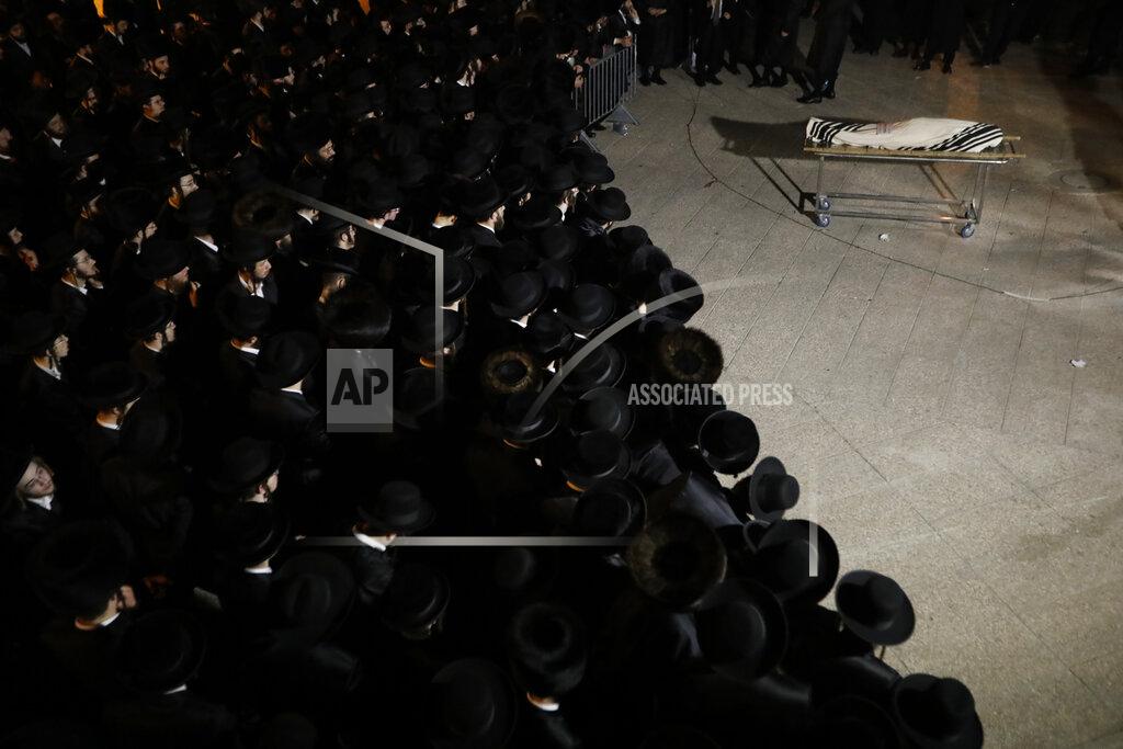 Ariel Schalit Ultra-Orthodox mourners gather around the body of Menachem Knoblowitz, 21, from the United States, who died during Lag BaOmer celebrations at Mt. Meron in northern Israel, at his funeral in Jerusalem on Saturday, May 1 2021. A stampede at a religious festival attended by tens of thousands of ultra-Orthodox Jews in northern Israel killed dozens of people and injured about 150 early Friday, medical officials said. It was one of the country's deadliest civilian disasters. (AP Photo/Ariel Schalit)