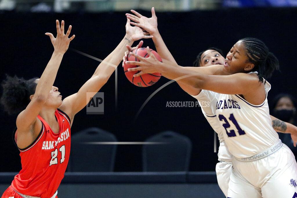 Michael Wyke Stephen F. Austin forward Aiyana Johnson, right, pulls in the rebound from Sam Houston State forward Madelyn Batista, left, in front of Avery Brittingham, back, during the first half of an NCAA college basketball game for the Southland Conference women's tournament championship Sunday, March 14, 2021, in Katy, Texas. (AP Photo/Michael Wyke)