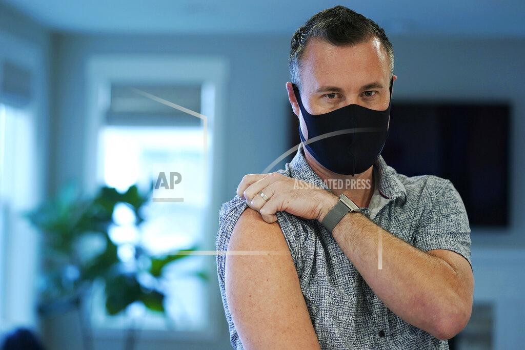 Ted S. Warren Neal Browning poses for a photo, Tuesday, March 9, 2021, in Bothell, Wash., north of Seattle. Earlier in the day, Browning, who was the second person to receive a shot nearly a year ago in the first-stage study of the Moderna COVID-19 vaccine, received a third shot as part of a new study of a one-year booster dose of the Moderna vaccine, which is now being widely used in worldwide vaccination efforts. Browning said that he has felt well since getting the third shot, except for some arm pain. (AP Photo/Ted S. Warren)