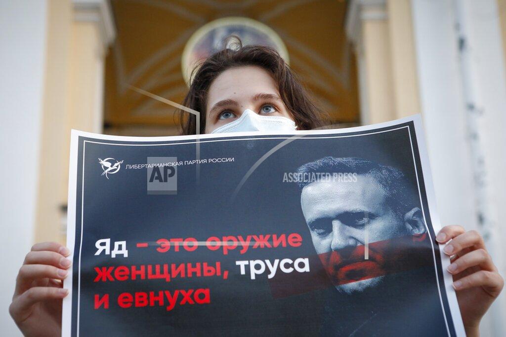 Elena Ignatyeva A protester stands holds a poster reads "poison is the weapon of a woman, a coward and a eunuch!" during a picket in support of Russian opposition leader Alexei Navalny in the center of St. Petersburg, Russia, Thursday, Aug. 20, 2020. Russian opposition politician Alexei Navalny is on a hospital ventilator in a coma, after falling ill from a suspected poisoning, according to his spokeswoman Kira Yarmysh. (AP Photo/Elena Ignatyeva)