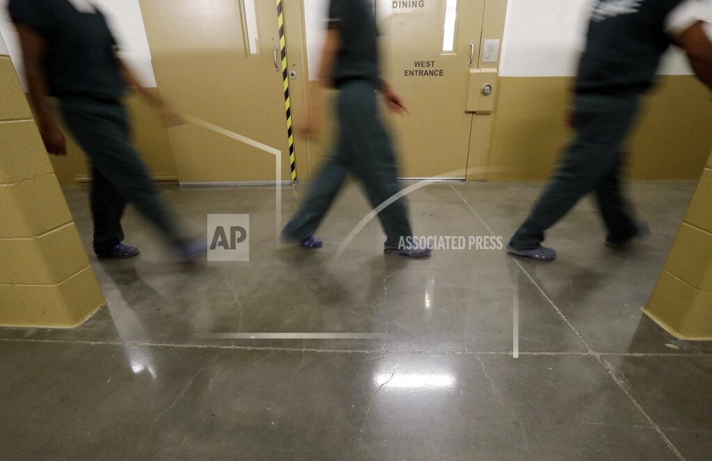 Gregory Bull Inmates walk down a hallway at the Otay Mesa Detention Center Wednesday, Aug. 23, 2017, in San Diego. The facility was at the center of the first big novel coronavirus outbreak at a U.S. immigration detention center in April 2020. (AP Photo/Gregory Bull)