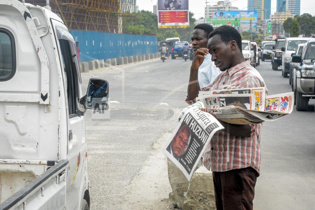 Uncredited A newspaper vendor holds papers with the front page headline in Swahili reading: "It is sad", reporting on the death of Tanzania's President John Magufuli, on a street in Dar es Salaam, Tanzania Thursday, March 18, 2021. President John Magufuli of Tanzania, a prominent COVID-19 skeptic whose populist rule often cast his country in a harsh international spotlight, died aged 61 of heart failure, it was announced by Vice President Samia Suluhu Hassan on Wednesday. (AP Photo)