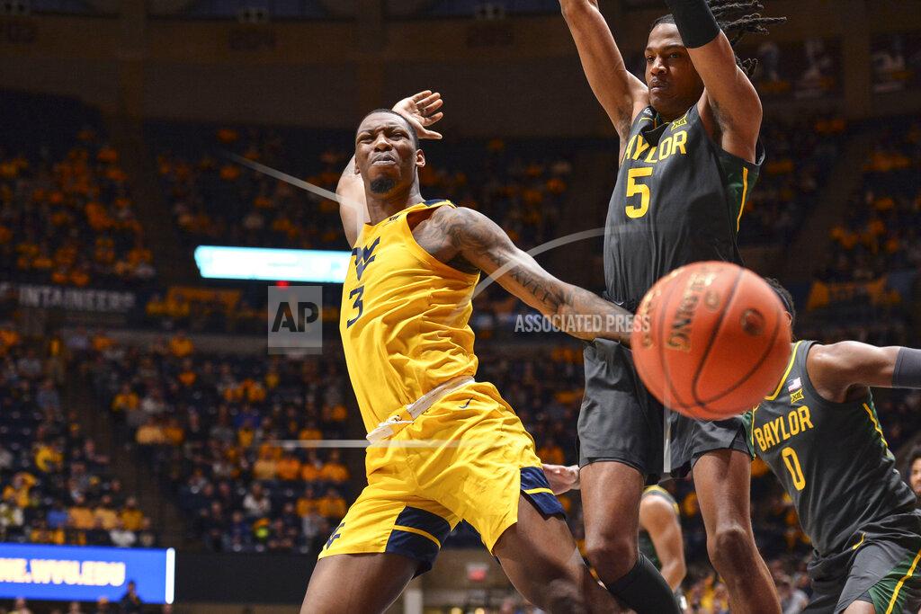 William Wotring West Virginia forward Gabe Osabuohien (3) looses the ball while being guarded by Baylor guard Jordan Turner (5) during the first half of an NCAA college basketball game in Morgantown, W.Va., Tuesday, Jan. 18, 2022. (William Wotring)
