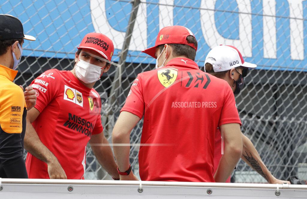 Luca Bruno Ferrari driver Carlos Sainz of Spain, second left, speaks with Ferrari driver Charles Leclerc of Monaco, second right, during the drivers parade prior to the Monaco Grand Prix at the Monaco racetrack, in Monaco, Sunday, May 23, 2021. (AP Photo/Luca Bruno)