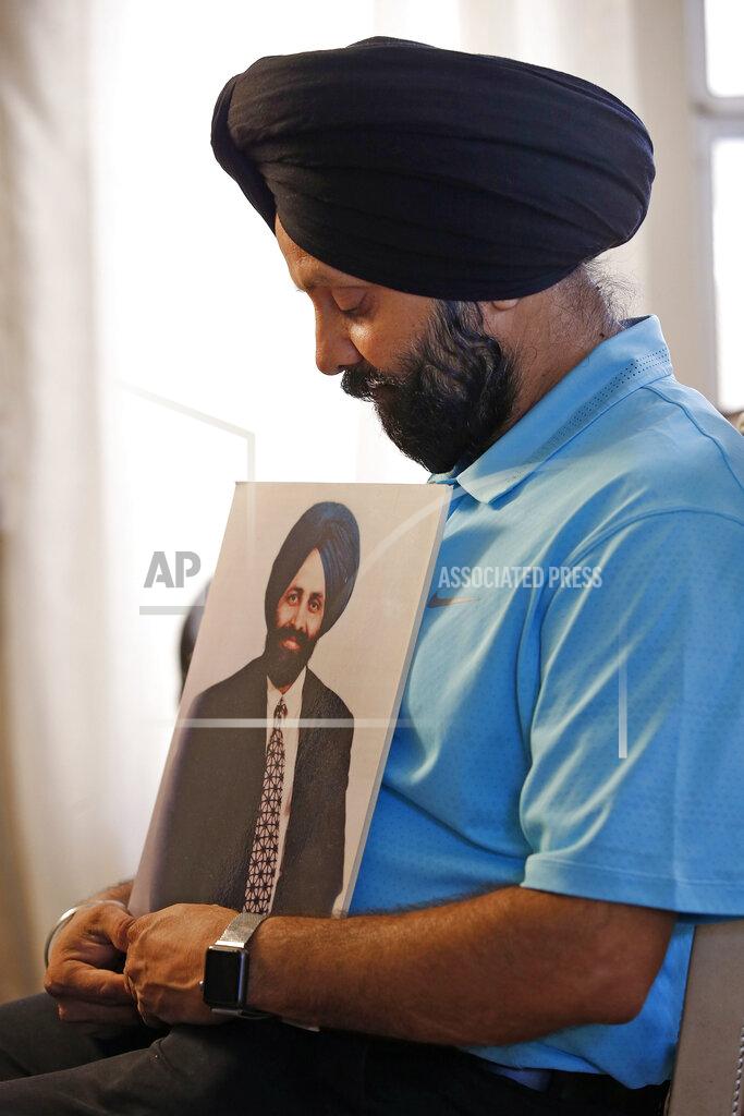 Ross D. Franklin FILE - In this Aug. 19, 2016 file photo Rana Singh Sodhi, holds a photograph of his murdered brother, Balbir Singh Sodhi, in Gilbert, Ariz. The Sikh American was killed at his Arizona gas station four days following the Sept. 11 attacks by a man who announced he was "going to go out and shoot some towel-heads" and mistook him for an Arab Muslim. (AP Photo/Ross D. Franklin,File)