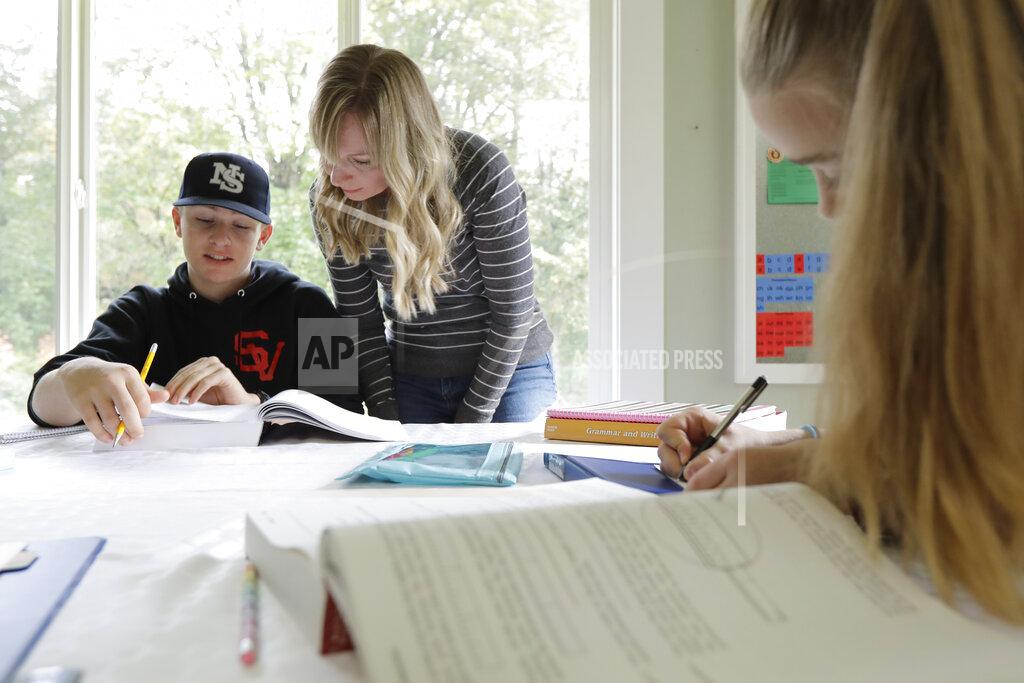 FILE - In this Oct. 9, 2019, photo, Donya Grant, center, works on a homeschool lesson with her son Kemper, 14, as her daughter Rowyn, 11, works at right, at their home in Monroe, Wash. The rate of households homeschooling their children doubled from the start of the pandemic last spring to the start of the new school year last September, according to a new U.S. Census Bureau report released this week. (AP Photo/Ted S. Warren, File)