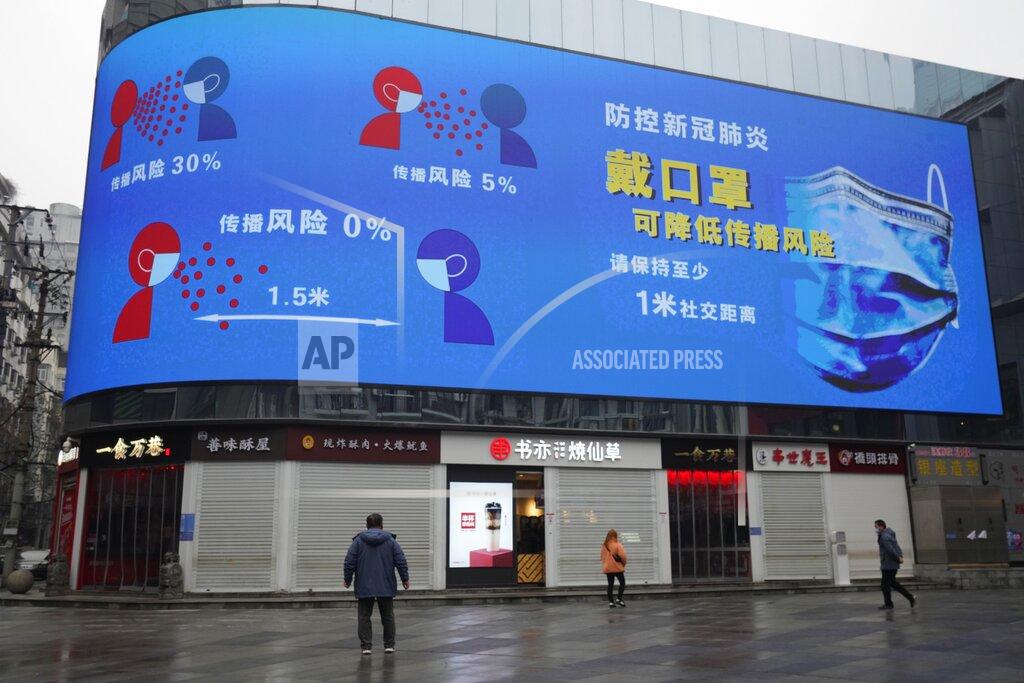 Ng Han Guan A man looks on near a giant display advocating the effectiveness of wearing masks to curb the spread of the coronavirus ahead of the anniversary of the 76-day lockdown of the city where the coronavirus was first detected in Wuhan in central China's Hubei province on Friday, Jan. 22, 2021. (AP Photo/Ng Han Guan)