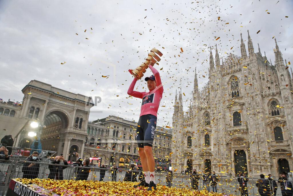 Luca Bruno Britain's Tao Geoghegan Hart, framed by the gothic cathedral, holds up the trophy after winning the Giro d'Italia cycling race, in Milan, Italy, Sunday, Oct. 25, 2020. (AP Photo/Luca Bruno)