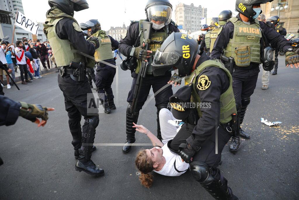 Rodrigo Abd Police detain a protester who was helping to block the road in front of the Justice Palace where people who are refusing to recognize the new government marched to protest, in Lima, Peru, Wednesday, Nov. 11, 2020. On Tuesday, Peru swore in Manuel Merino as president, after Peru’s legislature booted President Martin Vizcarra from office on Monday. (AP Photo/Rodrigo Abd)