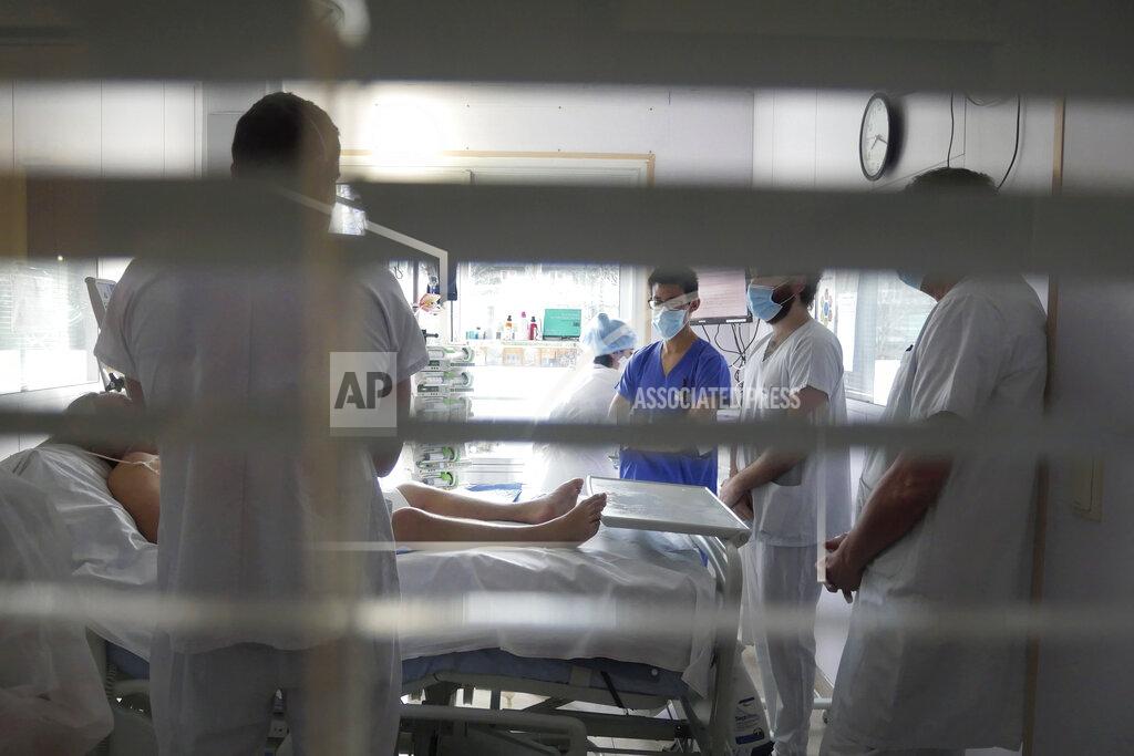 Thibault Camus FILE- In this March, 19, 2021, file photo, medical staff meets in a room of a patient affected by COVID-19 virus in the ICU unit at the Ambroise Pare clinic in Neuilly-sur-Seine, near Paris. France's president say he has nothing to be sorry about for refusing to impose a third virus lockdown earlier this year, even though his country is now facing surging infections that are straining hospitals and more than 1,000 people with the virus are dying every week. (AP Photo/Thibault Camus, File)