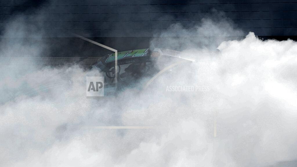 Paul Sancya Ty Gibbs celebrates by holding up his steering wheel while doing a burnout after winning the New Holland 250 NASCAR Xfinity Series auto race at the Michigan International Speedway in Brooklyn, Mich., Saturday, Aug. 6, 2022. (AP Photo/Paul Sancya)