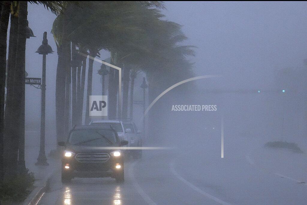 Joe Cavaretta Cars move along highway A1A with poor visability in Fort Lauderdale, Fla., Sunday, Nov. 8, 2020. A strengthening Tropical Storm Eta sliced across Cuba on Sunday and was aimed at the southern tip of Florida, where officials braced for a storm that could hit at hurricane force after leaving scores of dead and over 100 missing in Mexico and Central America. (Joe Cavaretta/South Florida Sun-Sentinel via AP)
