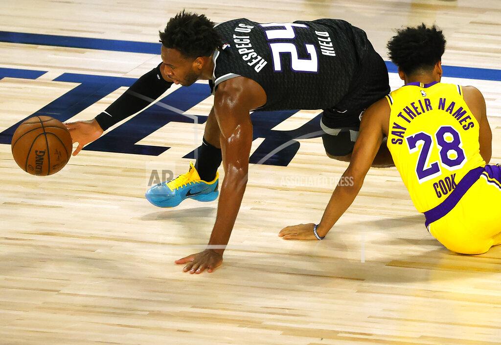 Kevin C. Cox Sacramento Kings' Buddy Hield (24) grabs the ball after colliding with Los Angeles Lakers' Quinn Cook (28) during the second quarter of an NBA basketball game Thursday, Aug. 13, 2020, in Lake Buena Vista, Fla. (Kevin C. Cox/Pool Photo via AP)