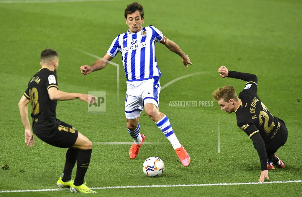 Alvaro Barrientos Real Sociedad's Mikel Oyarzabal fights for the ball against Barcelona's Jordi Alba and Ansu Fati, right, during the Spanish La Liga soccer match between Real Sociedad and FC Barcelona at Reale Arena stadium in San Sebastian, Spain, Sunday, March. 21, 2021. (AP Photo/Alvaro Barrientos)