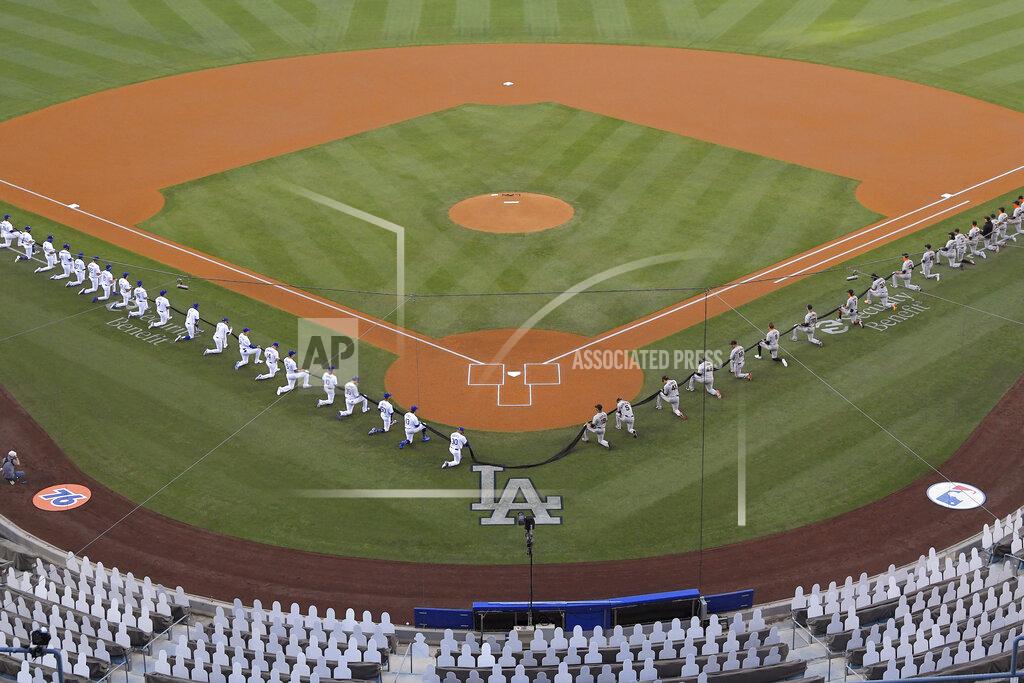 Mark J. Terrill Members of the Los Angeles Dodgers and the San Francisco Giants kneel during a moment of silence prior to an opening day baseball game Thursday, July 23, 2020, in Los Angeles. (AP Photo/Mark J. Terrill)