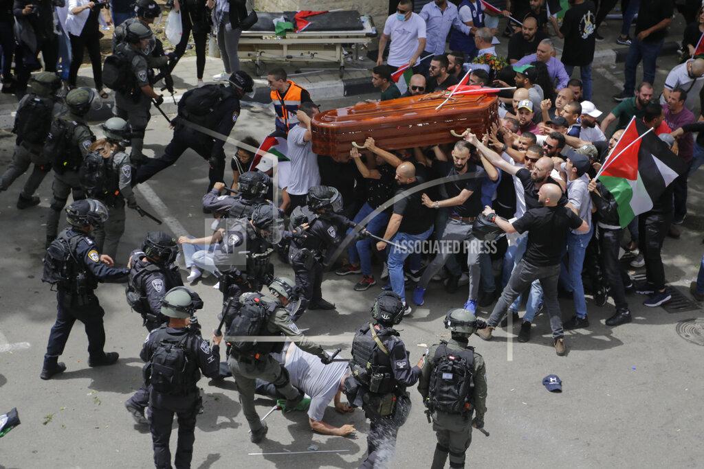 Maya Levin Israeli police confront with mourners as they carry the casket of slain Al Jazeera veteran journalist Shireen Abu Akleh during her funeral in east Jerusalem, Friday, May 13, 2022. Abu Akleh, a Palestinian-American reporter who covered the Mideast conflict for more than 25 years, was shot dead Wednesday during an Israeli military raid in the West Bank town of Jenin. (AP Photo/Maya Levin)