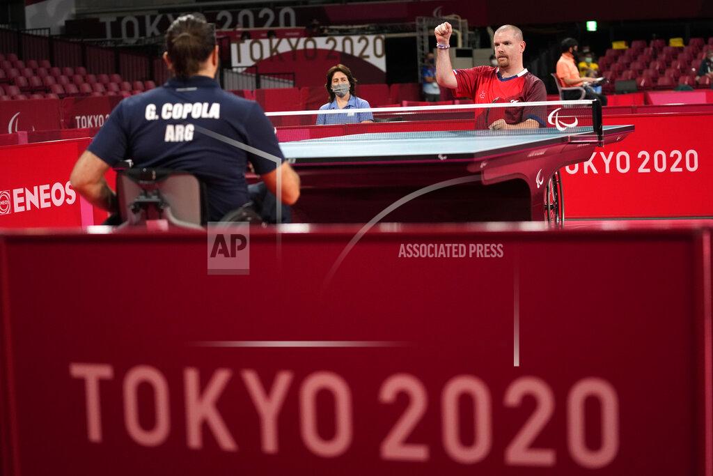 Eugene Hoshiko Florian Merrien, top right, of France and Gabriel Copola, top left, of Argentin play in Class 3, Group C of men's table tennis competition at the Tokyo 2020 Paralympic Games Wednesday, Aug. 25, 2021, in Tokyo, Japan. (AP Photo/Eugene Hoshiko)