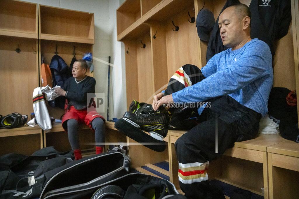 Mark Schiefelbein Members of the "1979" hockey club put on their gear in the locker room before a match at a hockey rink in Beijing, Wednesday, Jan. 12, 2022. Spurred by enthusiasm after China was awarded the 2022 Winter Olympics, the members of a 1970s-era youth hockey team, now around 60 years old, have reunited decades later to once again take to the ice. (AP Photo/Mark Schiefelbein)