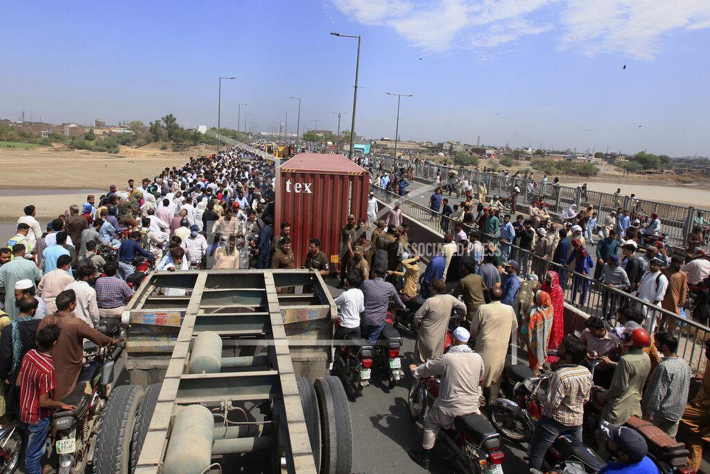 K.M. Chaudary People cross a bridge on Ravi River which is closed for traffic due to shipping containers placed by authorities in an attempt to foil a planned protest, in Lahore, Pakistan, Tuesday, May 24, 2022. Pakistan's key opposition party led by recently ousted Prime Minister Imran Khan accused police of detaining hundreds of its supporters in raids that started early Tuesday. (AP Photo/K.M. Chaudary)