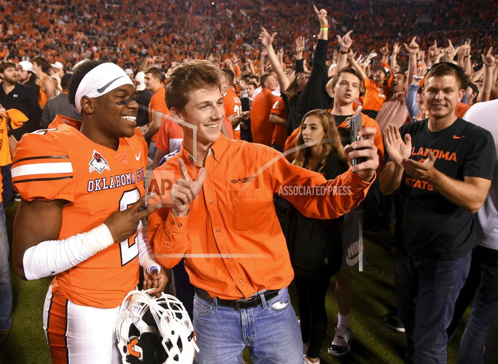 Brody Schmidt Oklahoma State wide receiver Tylan Wallace takes a photo with fans following an NCAA college football game in Stillwater, Okla., Saturday, Oct. 27, 2018. Wallace had two touchdowns in Oklahoma State's 38-35 win over Texas. (AP Photo/Brody Schmidt)