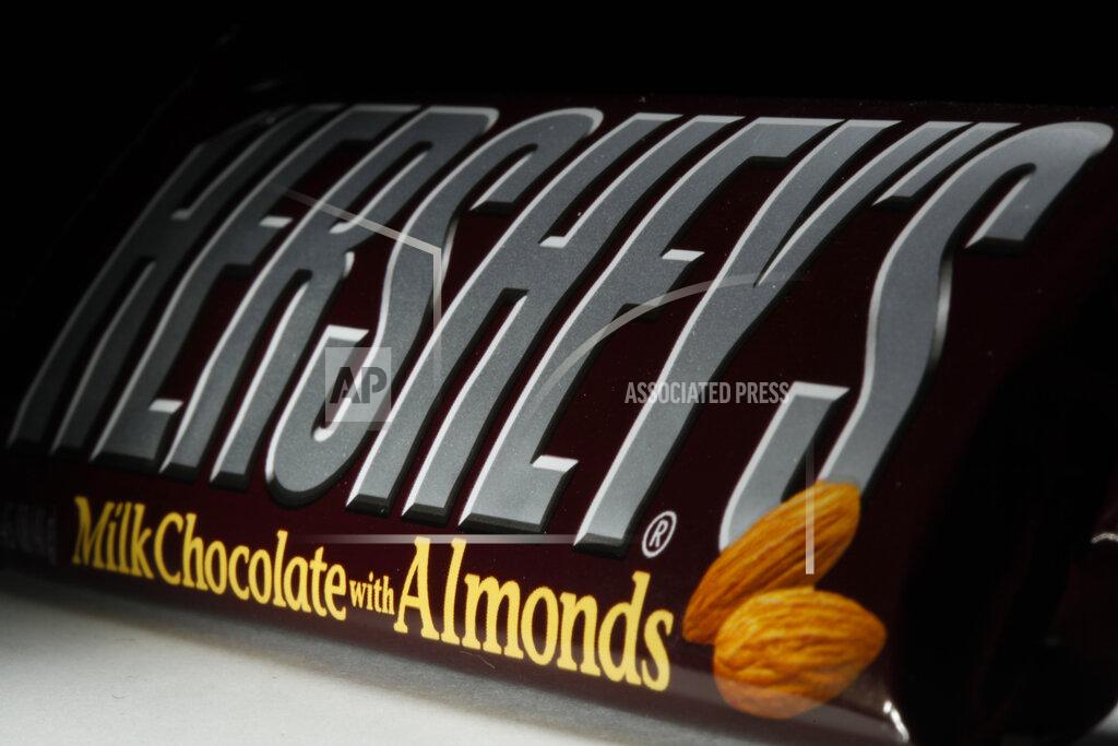 FILE - This April 21, 2020 file photo shows a Hershey's chocolate bar with almonds in Philadelphia. Hershey says its Halloween candy sales were up slightly this year despite lower enthusiasm for trick-or-treating amid the pandemic. Michele Buck _ chairman, president and CEO of The Hershey Co. _ said Friday, Nov. 6, 2020, that earlier shipments of Halloween candy to stores helped boost sales. (AP Photo/Matt Rourke, File)