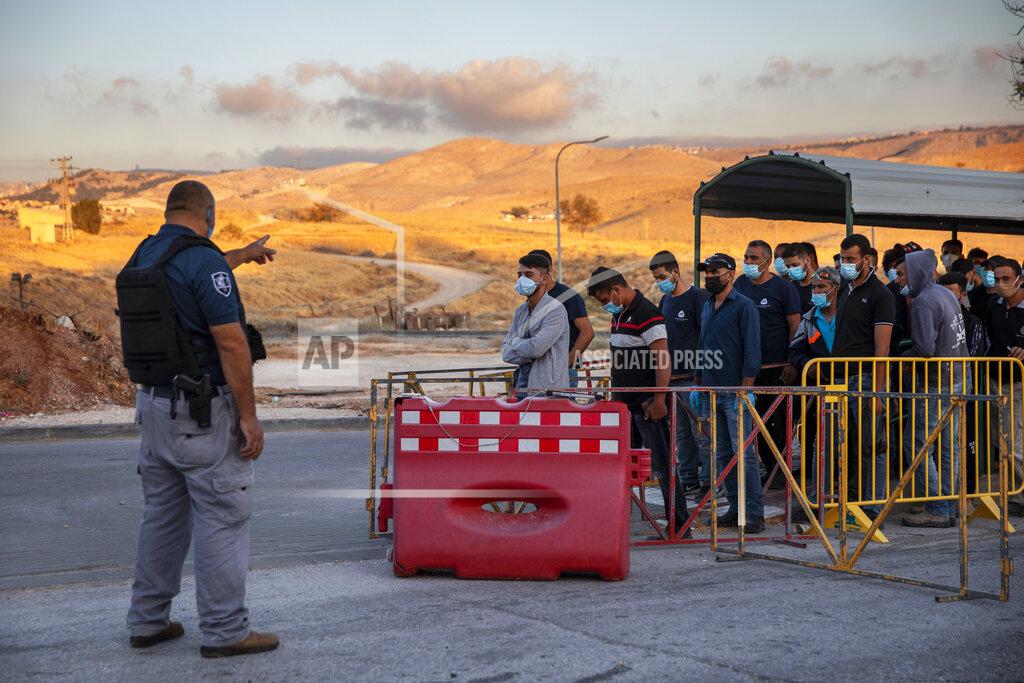 Oded Balilty Palestinians laborers line up to cross a checkpoint at the entrance to the Israeli settlement of Maale Adumim, near Jerusalem, Tuesday, June 30, 2020. Israeli Prime Minister Benjamin Netanyahu appears determined to carry out his pledge to begin annexing parts of the occupied West Bank, possibly as soon as Wednesday. (AP Photo/Oded Balilty)