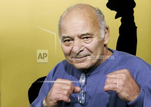 FILE - Burt Young, a cast member of the film &quot;Rocky Balboa,&quot; gestures at the premiere of the film in Los Angeles, Dec. 13, 2006. Burt Young, the Oscar-nominated actor who played Paulie, the rough-hewn, mumbling-and-grumbling best friend, corner-man and brother-in-law to Sylvester Stallone in the &ldquo;Rocky&rdquo; franchise, has died. Young died Oct. 8, 2023 in Los Angeles. (AP Photo/Kevork Djansezian, File)