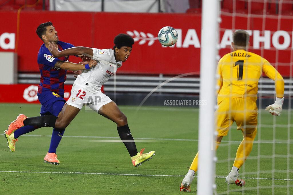 Angel Fernandez Barcelona's Luis Suarez, left, tries to stop Sevilla's Jules Kounde during the Spanish La Liga soccer match between Sevilla and FC Barcelona at the Ramon Sanchez-Pizjuan stadium in Seville, Spain, Friday, June 19, 2020. (AP Photo/Angel Fernandez)