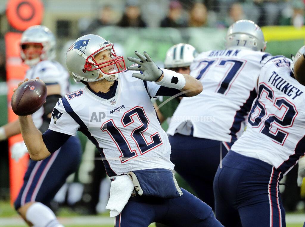 FILE - In this Nov. 25, 2018, file photo, New England Patriots quarterback Tom Brady (12) throws a pass as his offensive line blocks during the second half of an NFL football game against the New York Jets in East Rutherford, N.J. They're big boys with mean streaks and nasty attitudes on the field, yet the Patriots' offensive line still gets somewhat overlooked at times. During the playoffs, they've been as big a key as any position group by keeping Tom Brady clean and clearing the way for the running game. (AP Photo/Seth Wenig, File)