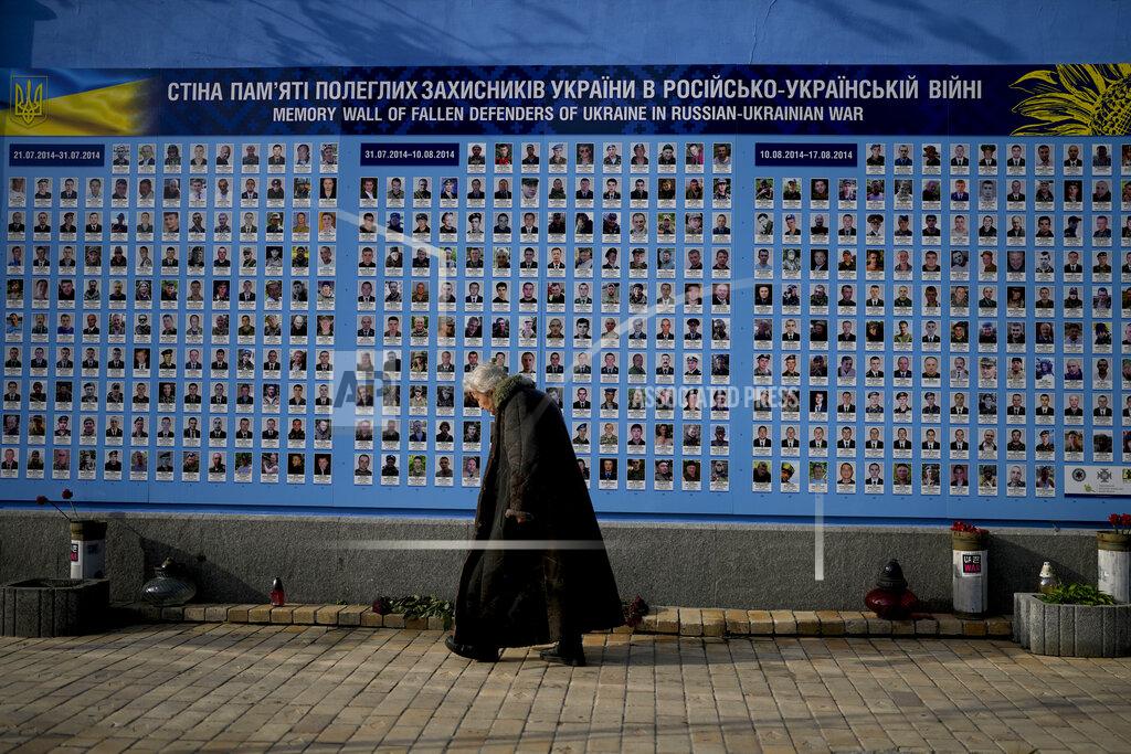 Natacha Pisarenko A woman walks past the Memorial Wall of Fallen Defenders of Ukraine in Russian-Ukrainian War in Kyiv, Ukraine, Monday, May 23, 2022. (AP Photo/Natacha Pisarenko)