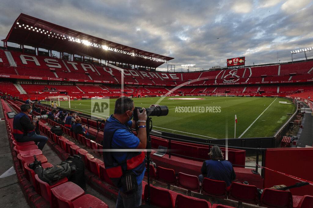 Str Press photographers shoot pictures before the start of the Spanish La Liga soccer match between Sevilla and Betis in Seville, Spain, Thursday, June 11, 2020. With virtual crowds, daily matches and lots of testing for the coronavirus, soccer is coming back to Spain. The Spanish league resumes this week more than three months after it was suspended because of the pandemic, becoming the second top league to restart in Europe. The Bundesliga was first. The Premier League and the Italian league should be next in the coming weeks. (AP Photo)