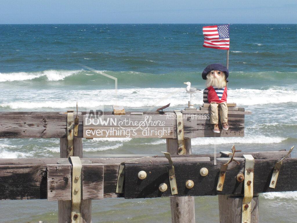 Wayne Parry "Ralph," a community mascot in Ocean Grove, N.J. sits at the edge of its oceanfront pier on Tuesday, May 25, 2021. Businesses and residents alike expect this summer at the Jersey Shore to be busier than last year as more people get vaccinated and COVID19 restrictions are scaled back or eliminated. (AP Photo/Wayne Parry)