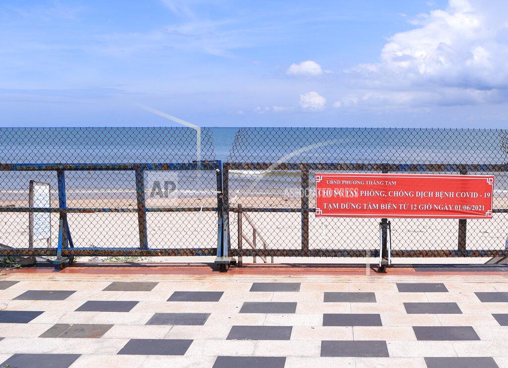 Hau Dinh Entrance to a beach is barricaded with sign read in Vietnamese "Fight COVID-19 together, no beach activities" in Vung Tau, Vietnam, Monday, Sept. 20, 2021. In Vung Tau, just outside Ho Chi Minh city, streets are sealed and checkpoints are set up to control the movement of people. Barbed wire, door panels, steel sheets, chairs and tables are among materials being used to fence up alleys and isolate neighborhoods.(AP Photo/Hau Dinh)