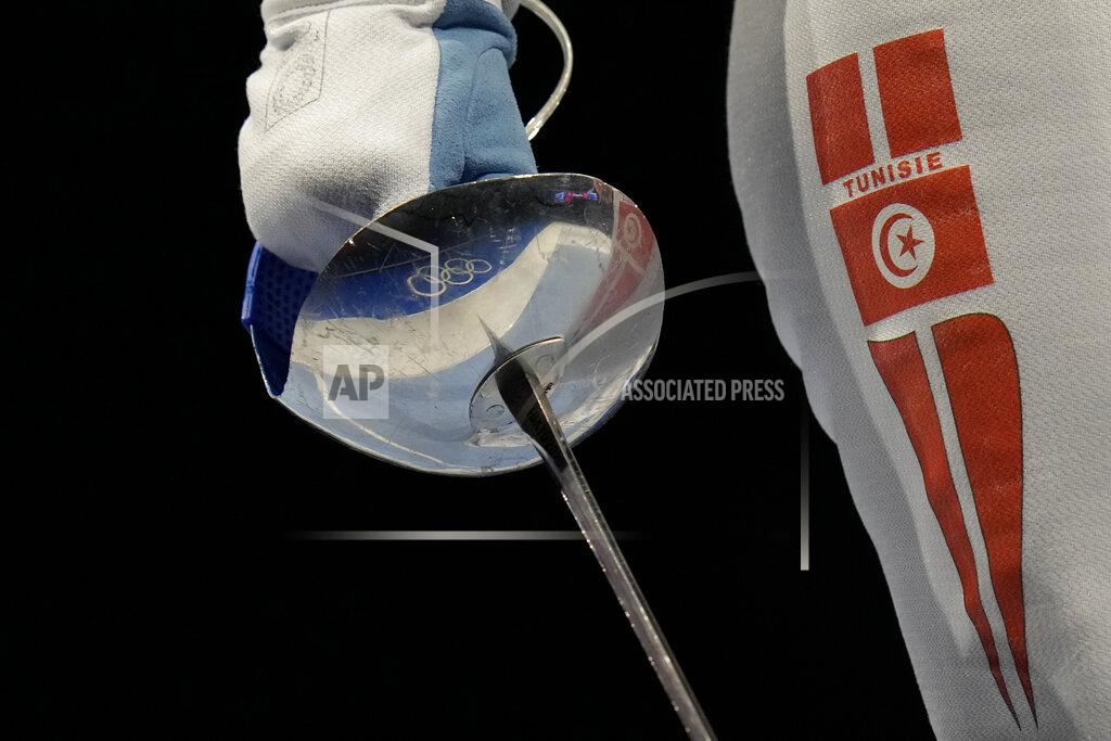 Hassan Ammar The Olympic rings are reflected on Sabre weapon of Olfa Hezami of Tunisia as competes with Norika Tamura of Japan in the women's Sabre team round of 16 competition at the 2020 Summer Olympics, Saturday, July 31, 2021, in Chiba, Japan. (AP Photo/Hassan Ammar)