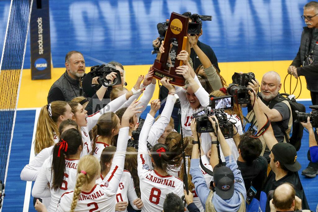 FILE - The Stanford women's volleyball team holds the championship trophy overhead after defeating Wisconsin for the NCAA Division I women's volleyball championship, in Pittsburgh, in this Saturday, Dec. 21, 2019, file photo. Women's volleyball will be the first of the NCAA fall sports to play this spring after the COVID-19 pandemic prompted most conferences to cancel or shorten their 2020 fall seasons and the NCAA to call off the national tournament. (AP Photo/Keith Srakocic, File)