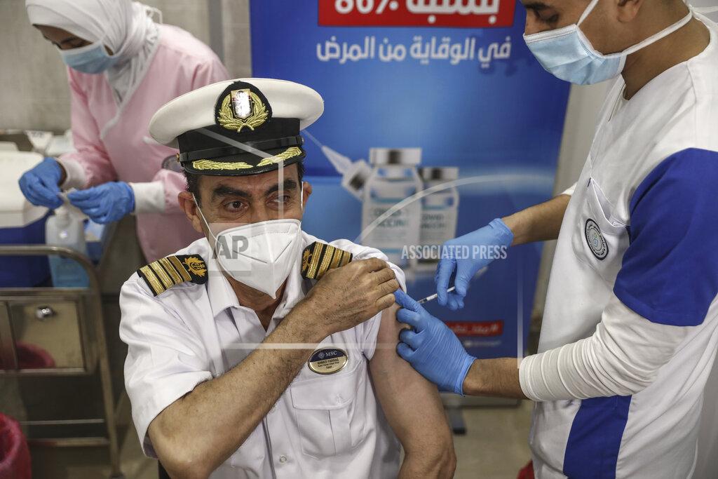 Mohamed Elshahed A Suec Cana pilot receives a COVID-19 vaccine in Ismailia, Egypt, Tuesday, April 6, 2021. The Suez Canal chief said Tuesday that authorities are negotiating a financial settlement with the owners of a massive vessel that blocked the crucial waterway for nearly a week. (AP Photo/Mohamed Elshahed)