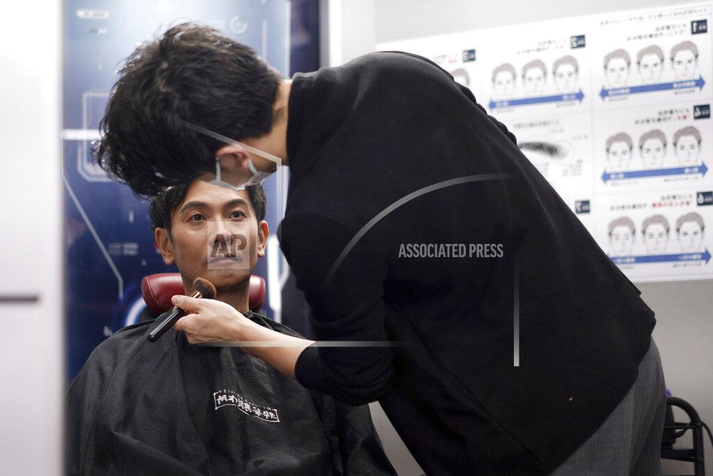 Eugene Hoshiko Yoshihiro Kamichi, a 44-year-old office worker, receives makeup and gets his hair done by a makeup artist at Ikemen-Works, a makeup salon for men, in Tokyo Wednesday, Feb. 3, 2021. The coronavirus pandemic has been pushing businesses to the edge in Japan, but some in the men's beauty industry have seen an unexpected expansion in their customer base. Japanese businessmen in their 40s, 50s and 60s who had little interest in cosmetics before the pandemic are now buying makeup. (AP Photo/Eugene Hoshiko)
