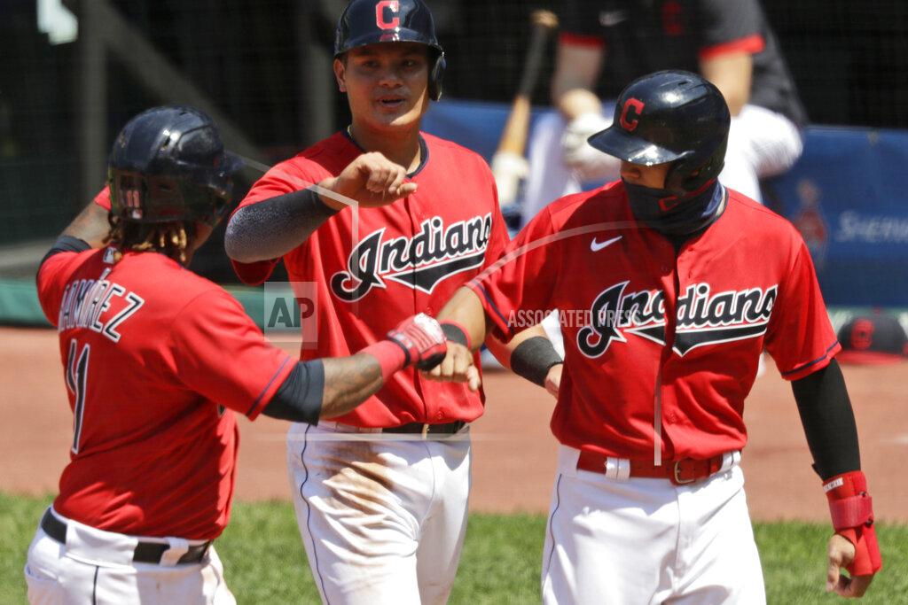From left to right, Cleveland Indians' Jose Ramirez is congratulated by Yu Chang and Cesar Hernandez after hitting a three-run home run in the fourth inning in a baseball game against the Kansas City Royals, Sunday, July 26, 2020, in Cleveland. (AP Photo/Tony Dejak)