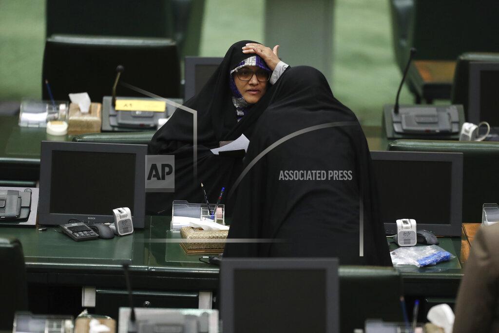 Vahid Salemi A lawmaker adjusts her veil as she talks with a colleague during the inauguration of Iran's new parliament, in Tehran, Iran, Wednesday, May, 27, 2020. Iran has convened its newly elected parliament, dominated by conservative lawmakers and under strict social distancing regulations, as the country struggles to curb the spread of coronavirus that has hit the nation hard. Iran is grappling with one of the deadliest outbreaks in the Middle East. (AP Photo/Vahid Salemi)