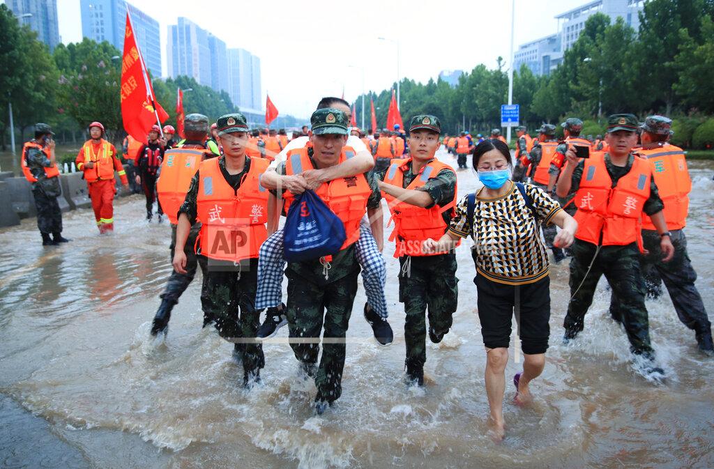 Uncredited Chinese military personnel evacuate residents from a hospital where about 3,000 people were trapped by the flood in Zhengzhou in central China's Henan province Thursday, July 22, 2021. Residents of the storm-ravaged central Chinese city of Zhengzhou on Thursday were shoveling mud from their homes and hauling away wrecked cars and piles of destroyed belongings following floods that killed at least 33 people in the city and surrounding areas. (Chinatopix Via AP)